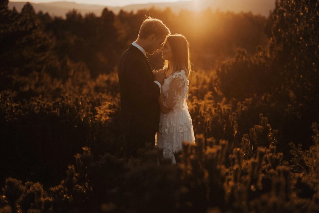 A couple in love sharing an intimate moment in nature during a warm sunset.