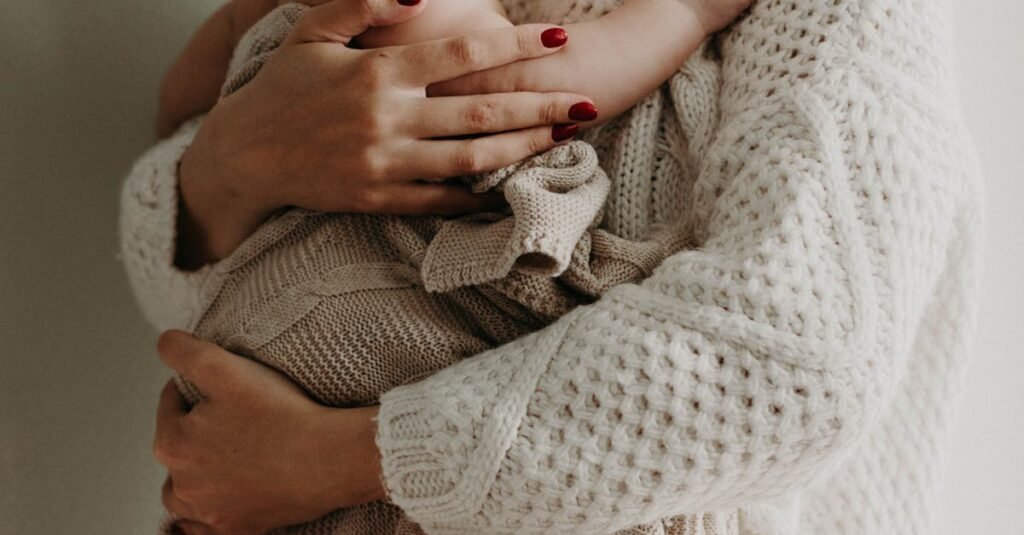 Close-up of a mother holding her baby in warm knitwear, conveying love and togetherness.